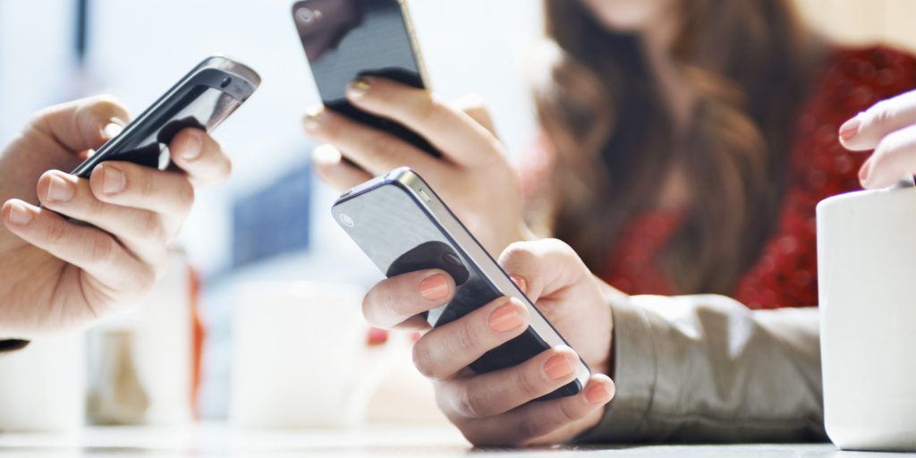 hands texting with mobile phones in cafe